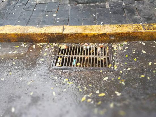 位于东城南池子大街的几家餐馆门前,雨水口散发着酸腐气味,铸铁的篦子上油垢明显。摄影 东城城管 张文侠