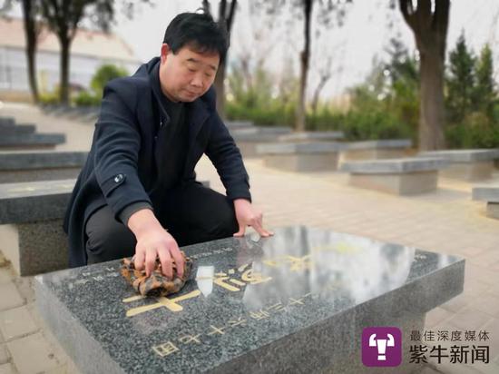 张景宪在擦拭无名烈士的墓碑