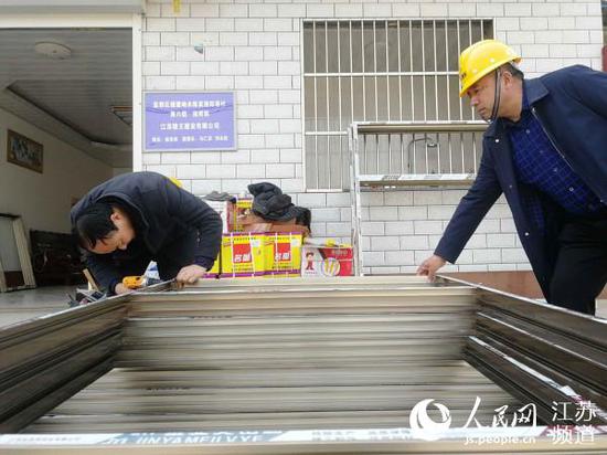 援建工人在测量新定制的门窗。记者王继亮摄