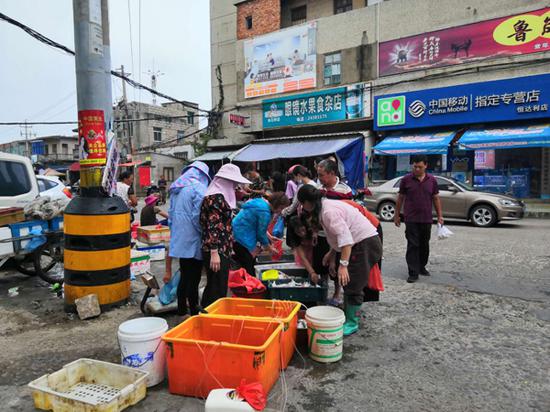 傍晚时分,平潭县澳前村集市上有人卖鱼。