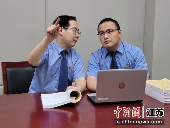 常州市钟楼区人民检察院金融犯罪办案组检察官朱晔与同事在分析案情。 唐娟 摄