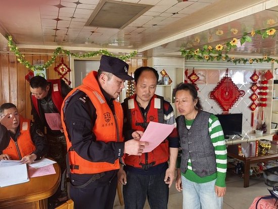  图释：水上公安局民警登船开展安全检查、普及反诈知识 拍摄：杨群