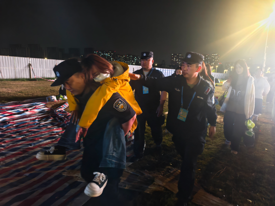 &nbsp;▲建邺分局民警在江豚音乐节安保执勤期间发现一名观众晕倒，民警背起群众撤离人群。拍摄：王政通