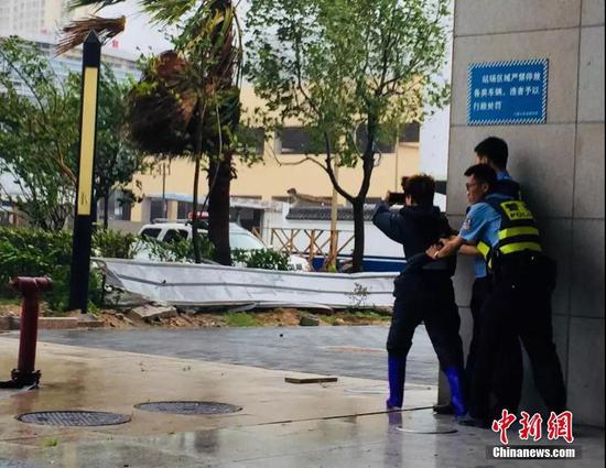 福建省宁德市区,记者在风雨中进行直播。林冬冬 摄