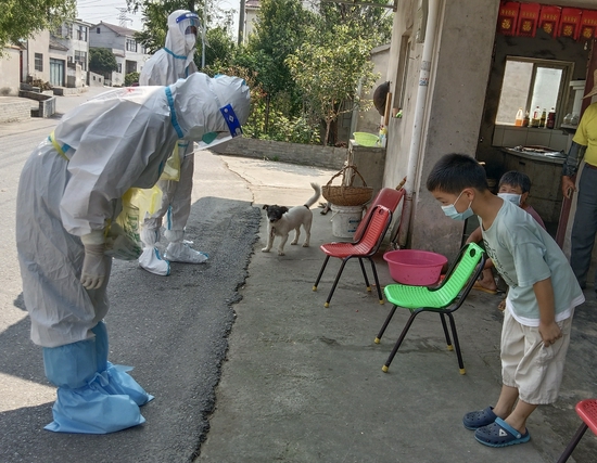 8月1日中午,禄口街道陈巷社区倪家村,盐城响水前来支援南京抗疫的护士葛佳佳为王宇新小朋友采集咽拭子后,王宇新向葛佳佳深深一鞠躬致谢,葛佳佳也躬身回礼。