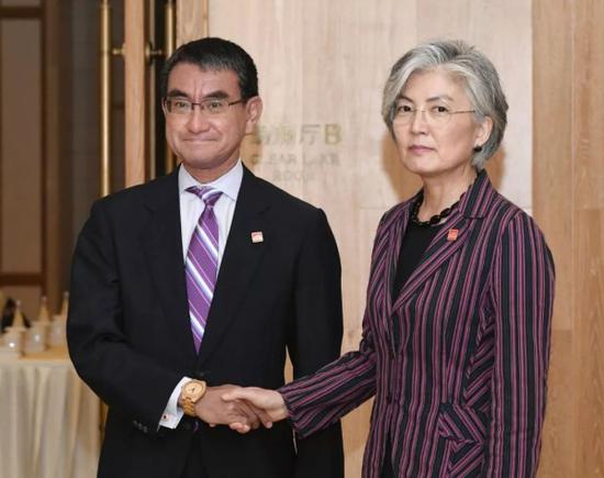韩国外交部长官康京和(右)和日本外相河野太郎在进行双边会晤前握手合影。