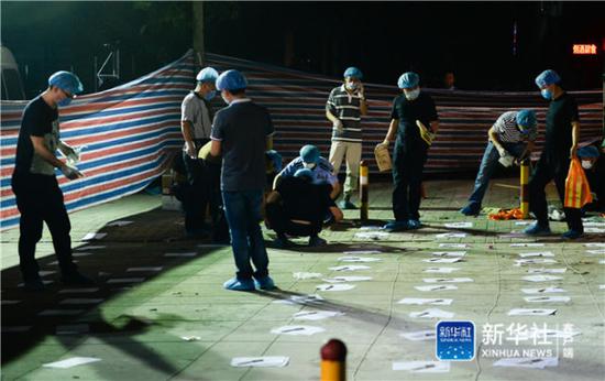 ↑6月16日凌晨,法医等工作人员在江苏省丰县创新幼儿园门前做清理、鉴定工作。新华社记者李响摄
