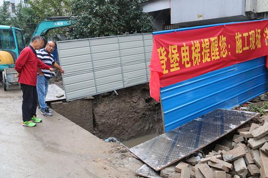 杨老师(红衣者)与施工人员交流。