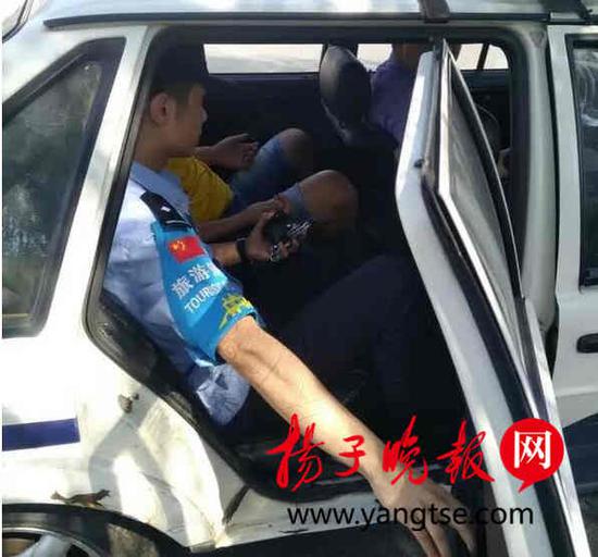 图为汪某被警方控制上车进一步处理。祝隽 摄