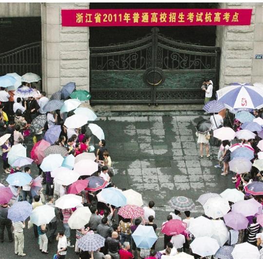 2011年高考首日下暴雨,考点外都是打伞的家长,十分壮观。 本报记者 吴煌 摄