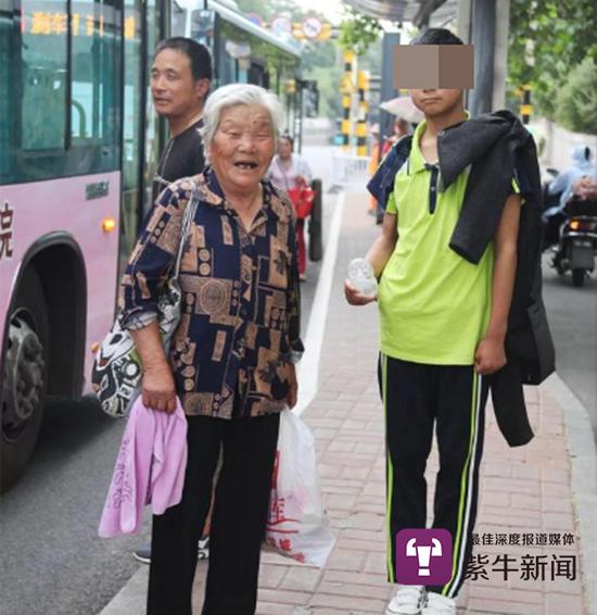 祖孙俩在等待回家的公交车(吕品摄)