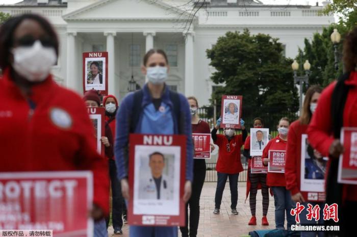 当地时间4月21日，美国华盛顿，美国最大的护士工会部分成员手举已感染新冠肺炎的同事照片，在白宫前呼吁政府加大力度投入生产防护设备。
