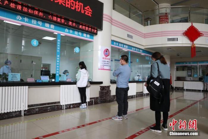 资料图:市民在医院门诊大厅间隔排队挂号。中新社记者 杨迪 摄