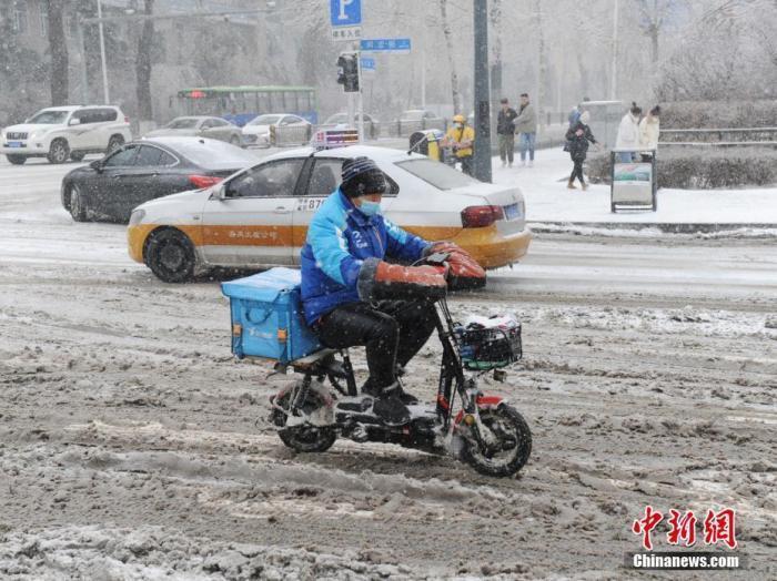 资料图:外卖小哥冒雪送餐。 中新社记者 刘栋 摄
