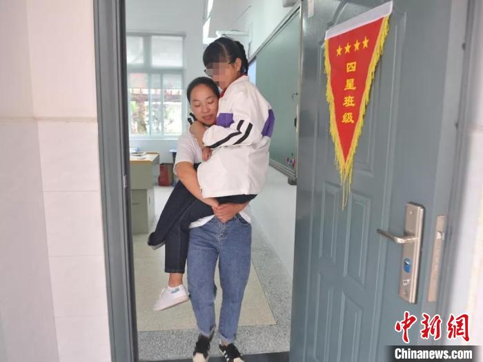 母亲背着陈雨欣走出教室。新区小学供图