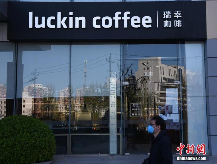 资料图:一名行人经过瑞幸咖啡北京宝能大厦店前。中新社记者 侯宇 摄