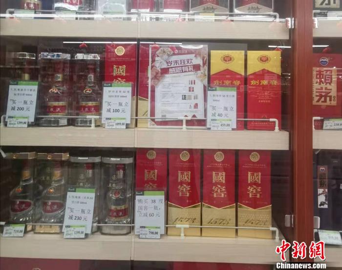 在北京一家超市内,多个品牌白酒在搞促销。 谢艺观 摄