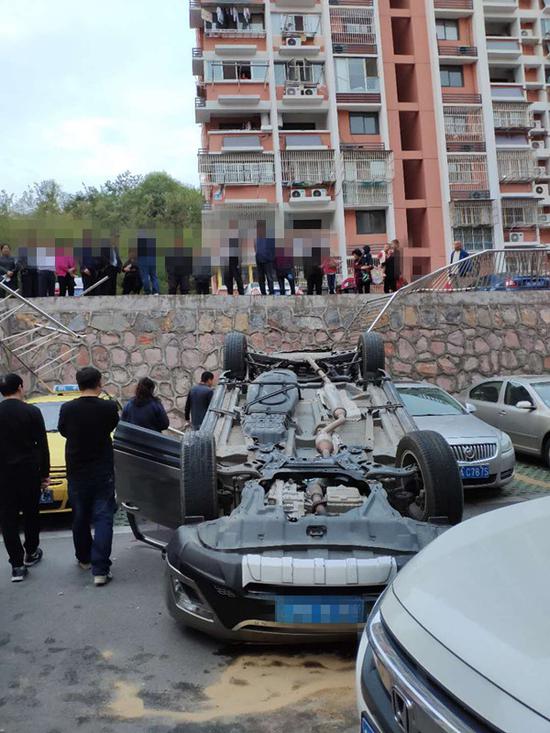 司机倒车误操作 车辆冲断围栏翻下高台底朝天