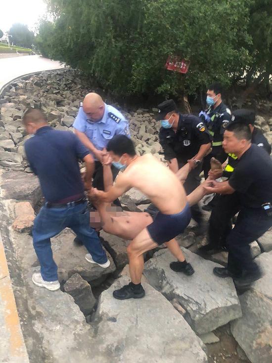 众人合力将轻生男子抬到平整地面