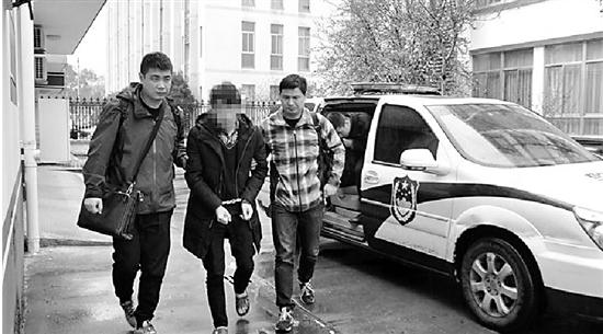 嫌疑人龙某(中)被警方从湖南带回。