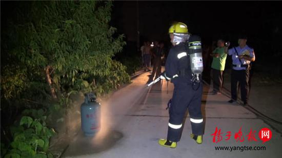 老人烧饭煤气罐着火 消防员冒着生命危险拎出煤气罐