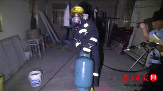 老人烧饭煤气罐着火 消防员冒着生命危险拎出煤气罐