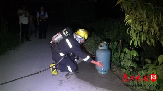 老人烧饭煤气罐着火 消防员冒着生命危险拎出煤气罐