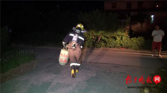 老人烧饭煤气罐着火 消防员冒着生命危险拎出煤气罐