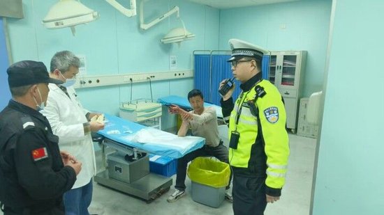 图释：交警将受伤工人紧急护送至医院 拍摄：胡园园