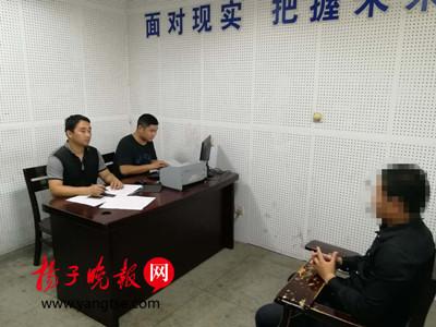 图为警方审讯胡某。