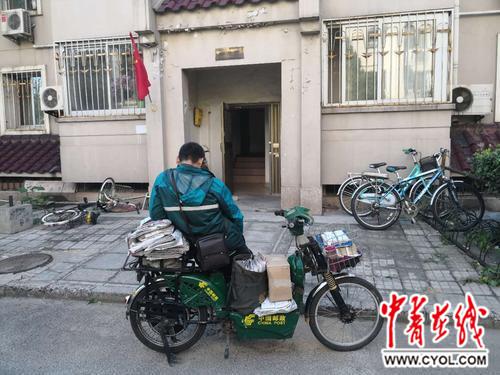 邮政小哥假日在楼道口静等邮件的主人。@坤哥007/摄