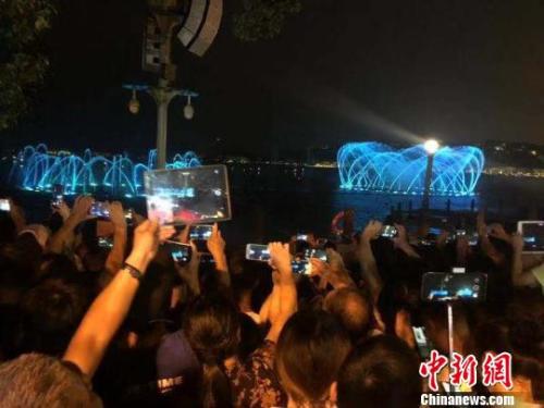 游客用手机记录下音乐喷泉的美丽瞬间