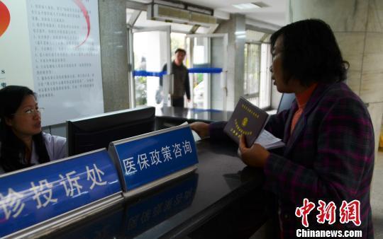 资料图。一名女子在医保政策咨询台前咨询。
