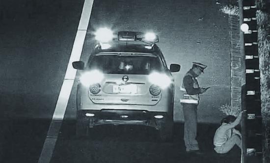 女子被民警拉到路边后,坐在地上大哭起来
