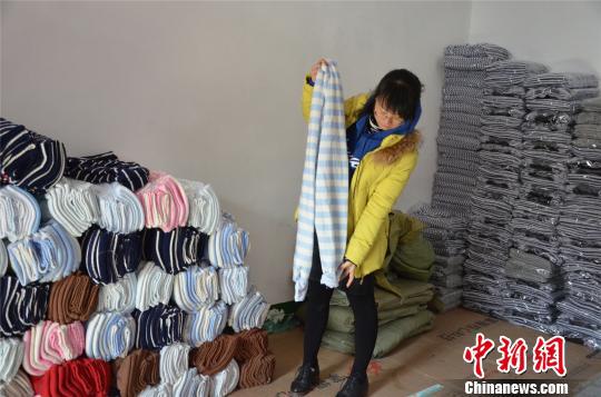 图为姚家坡村村民展示其生产的秋裤。 郝学娟 摄