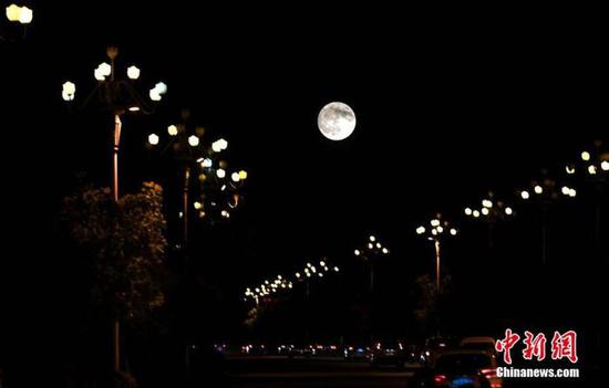 资料图:中秋之夜,福州圆月当空照。(多重曝光)中新社记者 王东明 摄
