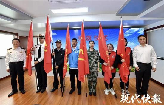 △ 江苏海事局党组成员郑跃峰和常州市委常委、高新区党工委书记周斌为长江大保护的志愿者团队代表们授旗