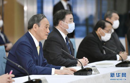 4月13日,在日本东京,日本首相菅义伟(左一)出席内阁会议。新华社/共同社