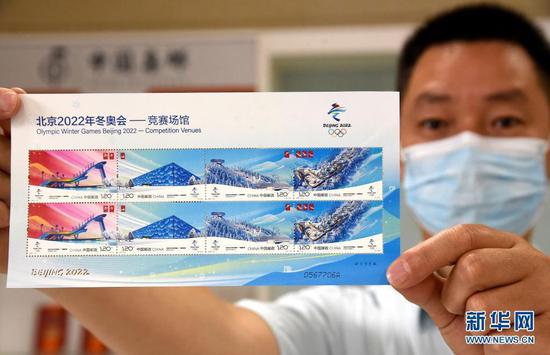 6月23日,中国邮政集团有限公司邯郸市分公司的工作人员展示《北京2022年冬奥会——竞赛场馆》纪念邮票。新华社发(郝群英 摄)
