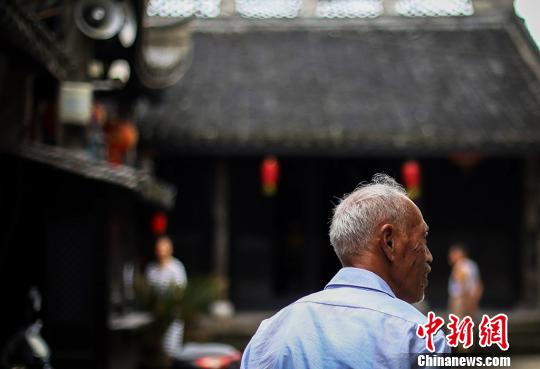 一位老人走在老街上,这里的一切都显的很安静。 泱波 摄