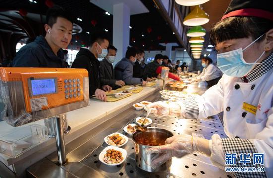 2月11日，在四川大学望江校区东二食堂，工作人员为就餐师生服务。新华社记者 江宏景 摄