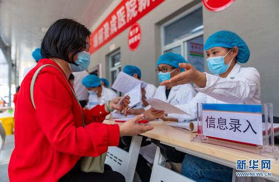 4月1日,在瑞丽市景成医院新冠疫苗接种点,一名女士在填写信息。新华社记者 陈欣波 摄