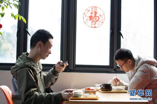 2月11日，在四川大学望江校区东二食堂，两位学生在吃午餐。新华社记者 江宏景 摄