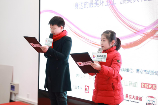 (小学生正在正情并茂的宣读《城市好看公益行动倡议书》)