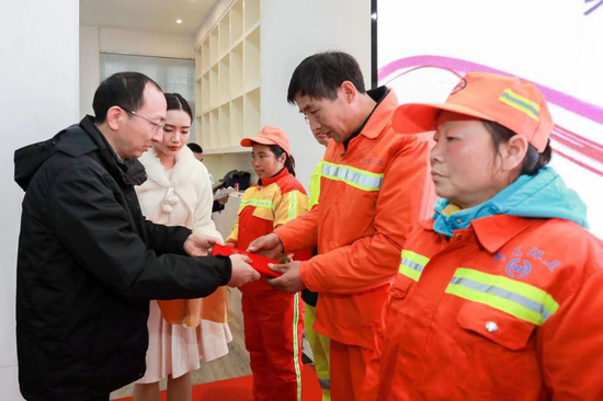 (南京报业传媒集团党委委员 金陵晚报总编辑 江飞给环卫工颁发荣誉证书)