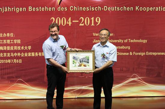 江苏理工学院党委书记王建华和梅泽堡应用技术大学校长Kirbs代表双方互赠礼物
