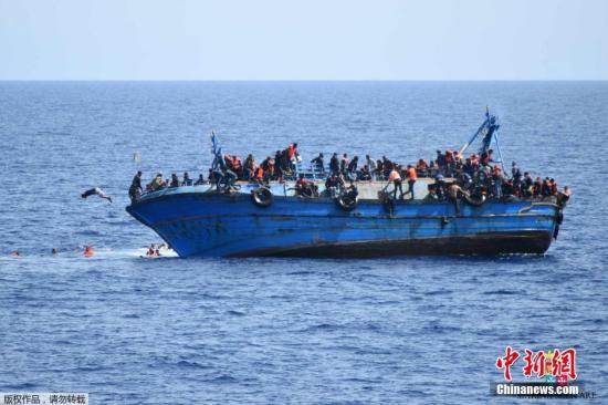 资料图片:当地时间2016年5月25日,利比亚近海海域,一艘满载难民的船只即将倾覆,船上的难民纷纷跳海逃生。