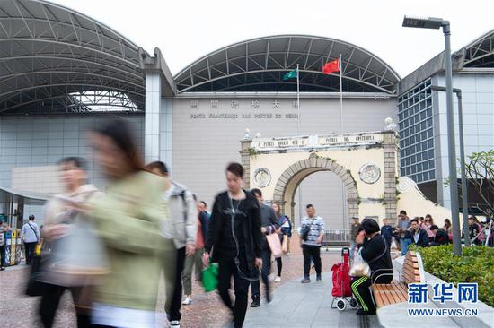 1月10日,市民和旅客通过澳门关闸口岸广场。新华社记者 张金加 摄