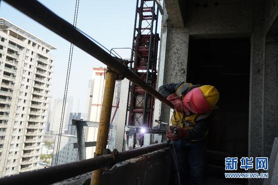 3月14日,在南京葛洲坝长江尊邸项目工地,工人在施工。新华社记者 季春鹏 摄