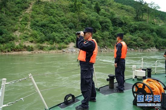 1人死亡、6人失踪 6月26日,水上巡逻总队队员在搜救船甲板上用望远镜搜寻。新华社发(陈欣波 摄)